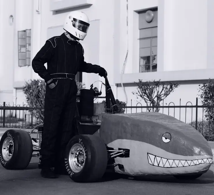 Team Srijan driver standing beside an early formula-style car